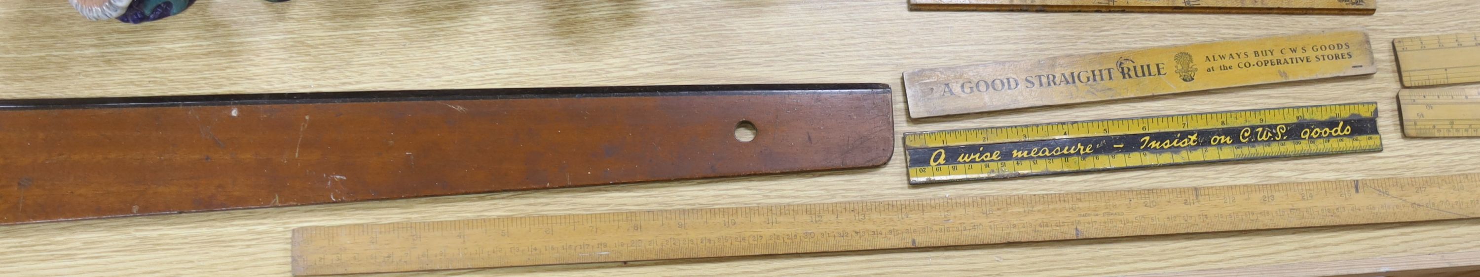 A group of rules and measures including three advertising rulers, longest 114cm